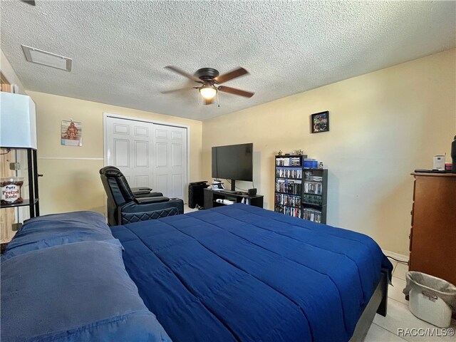 bedroom featuring a textured ceiling, a closet, and ceiling fan