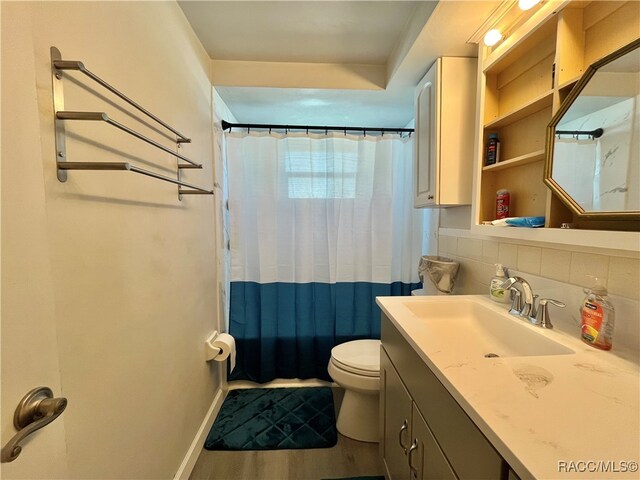 full bathroom with backsplash, wood-type flooring, toilet, shower / tub combo with curtain, and vanity