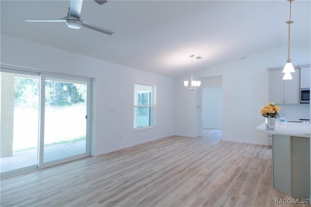 97 W Camino Ln, Citrus Springs, FL 34434 - unfurnished living room featuring baseboards, vaulted ceiling, ceiling fan with notable chandelier, and light wood-style floors
