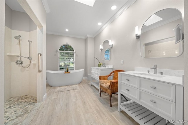 bathroom with hardwood / wood-style floors, shower with separate bathtub, crown molding, and vanity