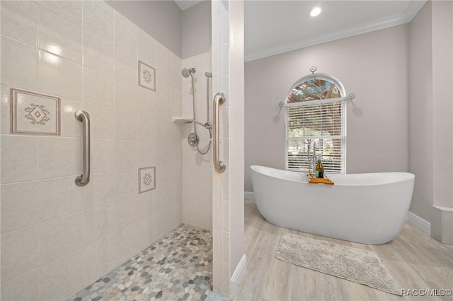 bathroom with crown molding, plus walk in shower, and wood-type flooring