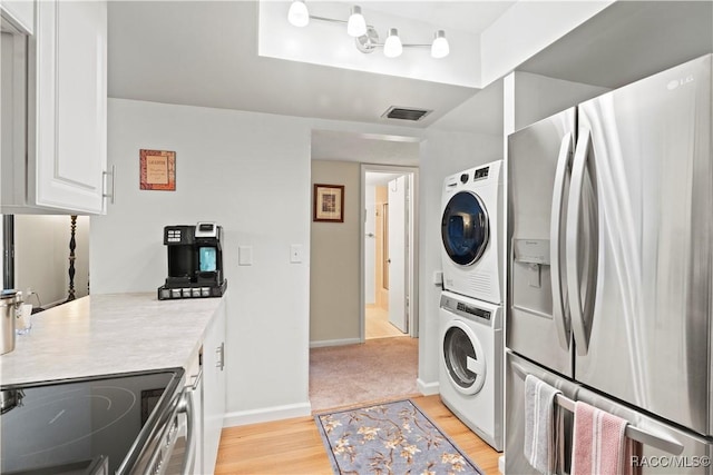 688 Midway Dr Unit B, Ocala, FL 34472 - washroom with estacked washer and dryer, light wood-style flooring, and baseboards