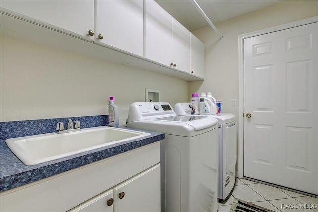 washroom featuring cabinets, washer and dryer, sink, and light tile patterned floors