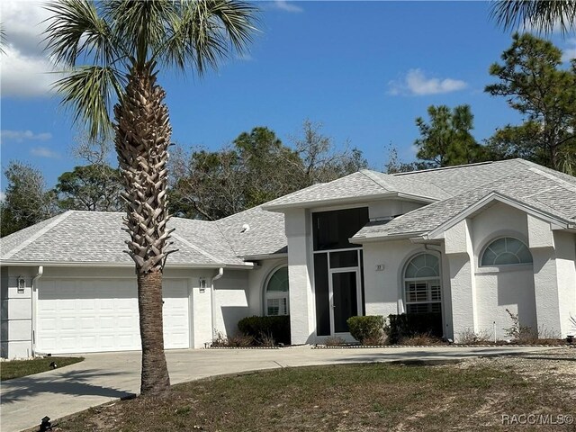 single story home with a garage and a front lawn