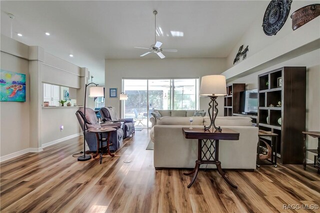 living room featuring hardwood / wood-style floors and ceiling fan