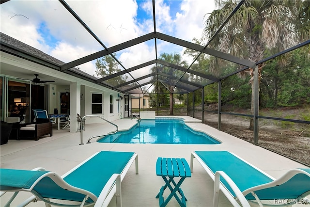 view of swimming pool with a patio, ceiling fan, and glass enclosure