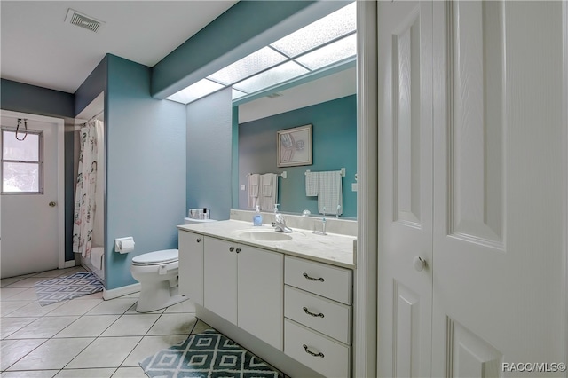 bathroom featuring toilet, tile patterned flooring, vanity, and walk in shower