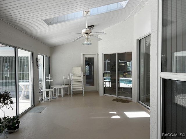 unfurnished sunroom featuring ceiling fan and lofted ceiling with skylight