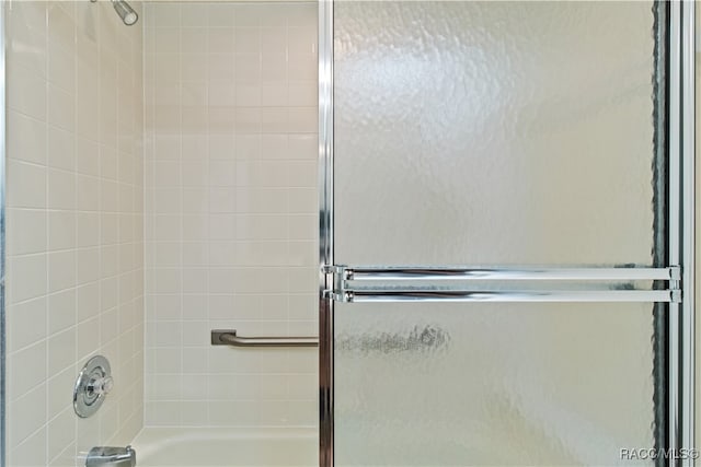 bathroom with shower / bath combination with glass door