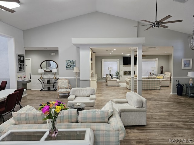 living room with hardwood / wood-style floors, ceiling fan, and high vaulted ceiling