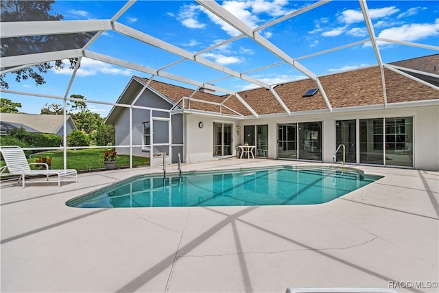 view of swimming pool with glass enclosure and a patio