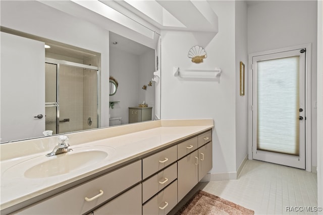 bathroom featuring tile patterned floors, vanity, toilet, and walk in shower