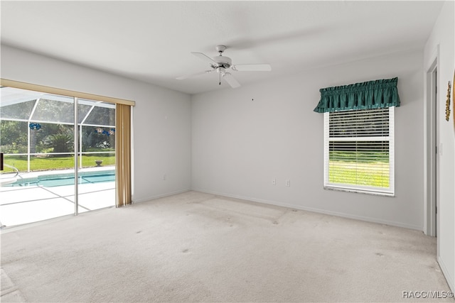 spare room with light carpet, ceiling fan, and a healthy amount of sunlight