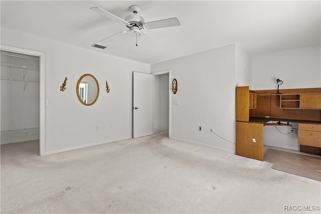 unfurnished living room with ceiling fan and light carpet