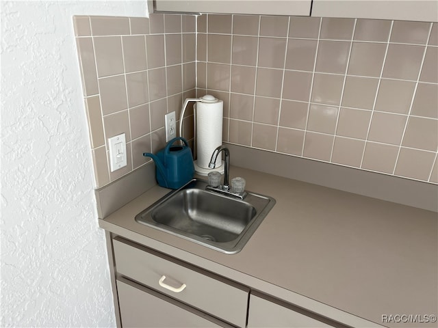 interior details featuring decorative backsplash and sink