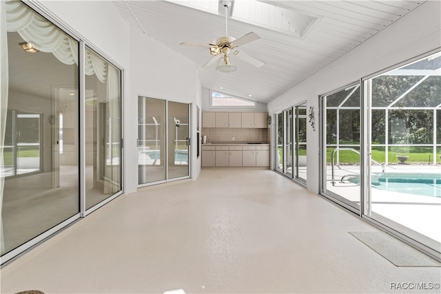 unfurnished sunroom featuring ceiling fan and vaulted ceiling