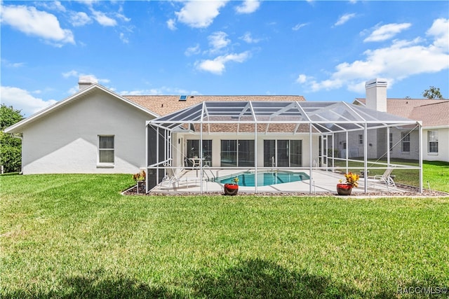 back of house featuring a patio, glass enclosure, and a lawn