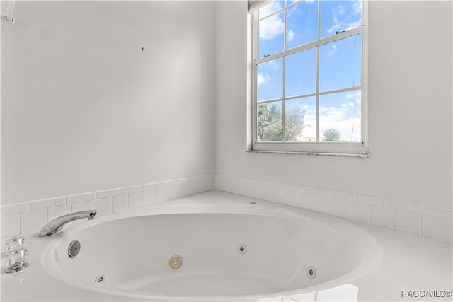 bathroom featuring a tub to relax in and a healthy amount of sunlight