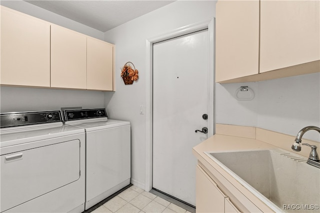 laundry area with cabinets, washing machine and dryer, and sink