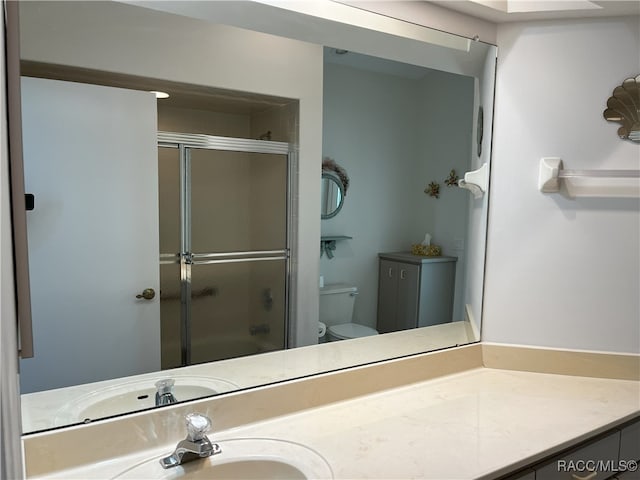 bathroom with vanity, toilet, and an enclosed shower