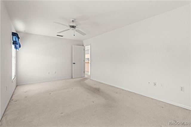 spare room featuring light carpet and ceiling fan