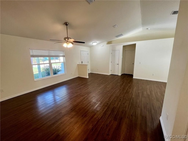 unfurnished room with lofted ceiling, dark wood-type flooring, visible vents, and baseboards