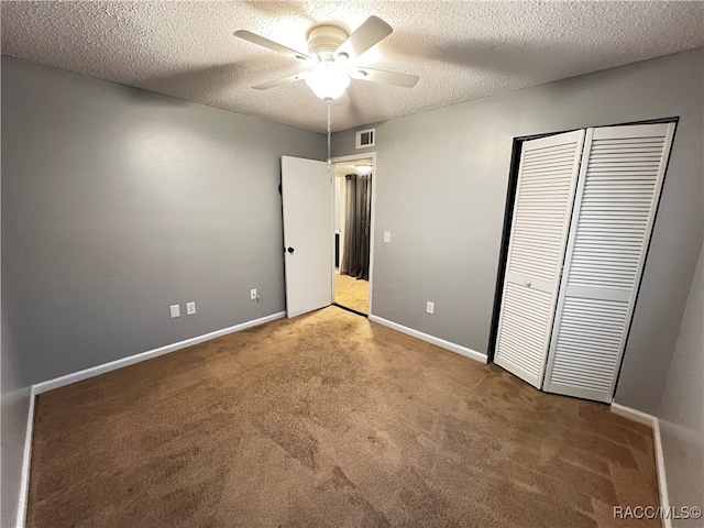 unfurnished bedroom featuring carpet, ceiling fan, a textured ceiling, and a closet