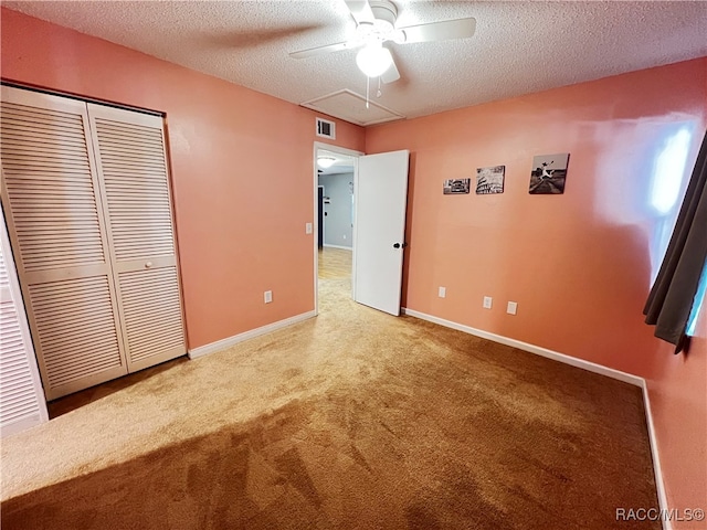 unfurnished bedroom featuring carpet flooring, ceiling fan, a textured ceiling, and a closet