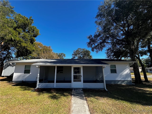 view of front of property featuring a sunroom and a front yard