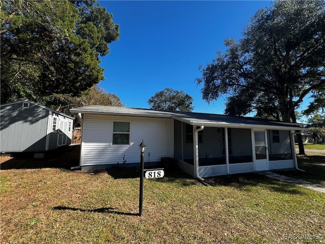 back of property featuring a yard and a sunroom