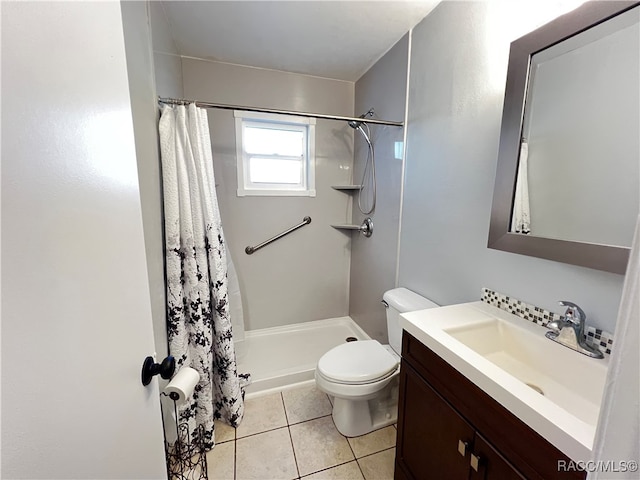 bathroom featuring tile patterned flooring, vanity, toilet, and walk in shower