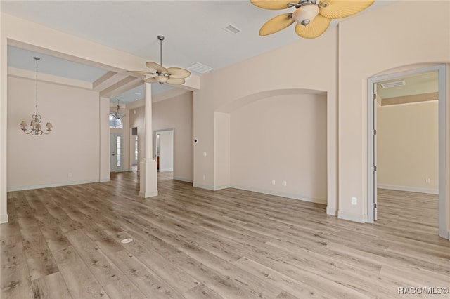 unfurnished living room featuring light hardwood / wood-style flooring and ceiling fan with notable chandelier