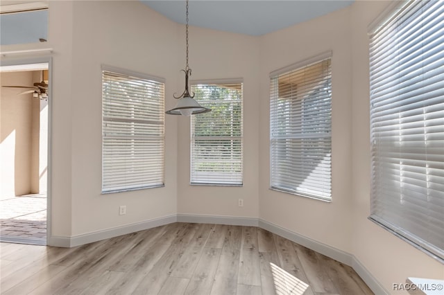 unfurnished dining area featuring ceiling fan and light hardwood / wood-style flooring