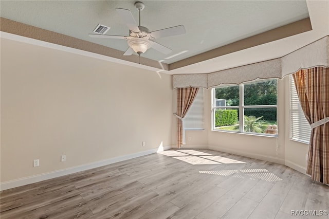 spare room with ceiling fan, light hardwood / wood-style floors, and a textured ceiling