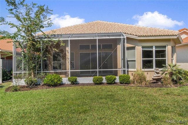 back of property featuring a lawn and a lanai