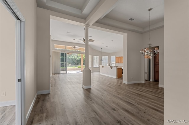 unfurnished living room with sink, ceiling fan with notable chandelier, and hardwood / wood-style flooring