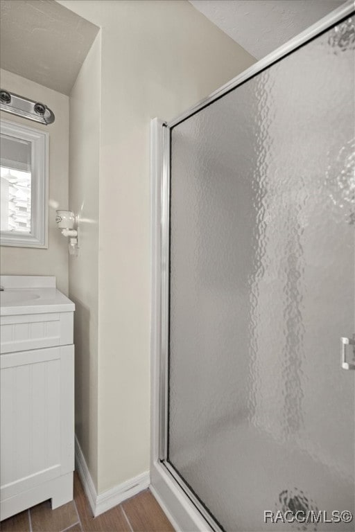 bathroom featuring hardwood / wood-style flooring, vanity, and walk in shower