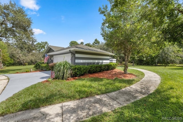 view of home's exterior with a garage and a yard