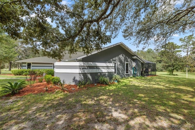 view of property exterior featuring glass enclosure and a lawn