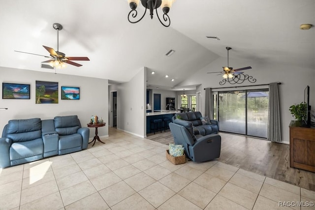 living room featuring vaulted ceiling, light tile patterned floors, and ceiling fan