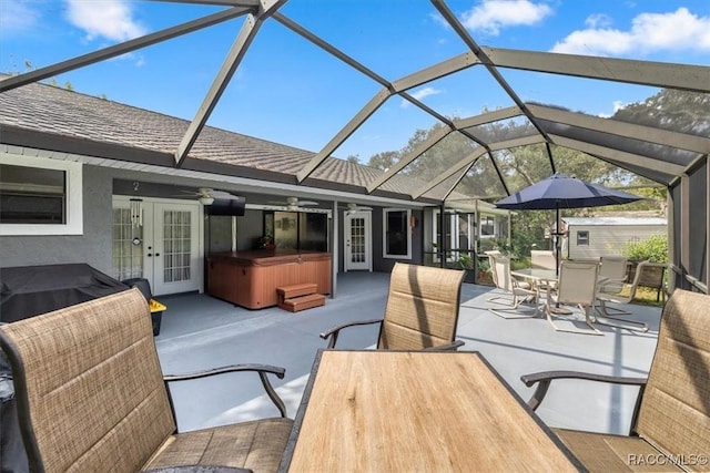 view of patio featuring a hot tub, a lanai, ceiling fan, and french doors