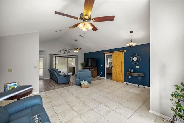 living room with light tile patterned flooring, ceiling fan, lofted ceiling, and a barn door