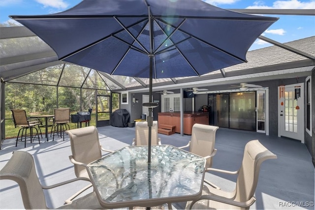 view of patio with ceiling fan, a hot tub, area for grilling, and a lanai