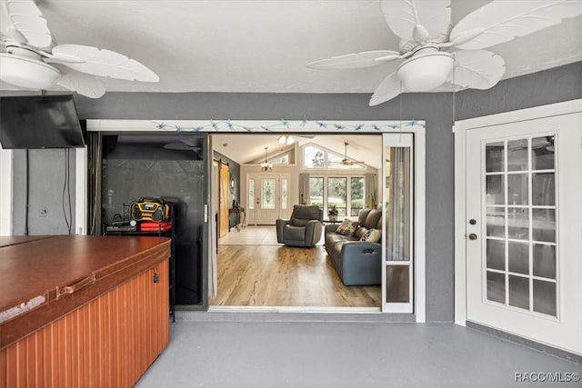 interior space featuring ceiling fan, concrete flooring, and vaulted ceiling