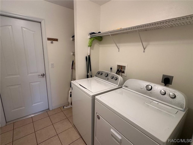 clothes washing area featuring washing machine and dryer and light tile patterned flooring