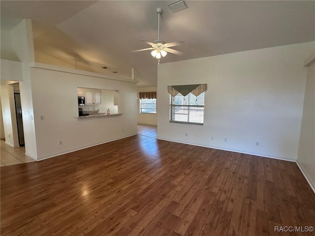 unfurnished living room featuring ceiling fan, lofted ceiling, and light hardwood / wood-style floors