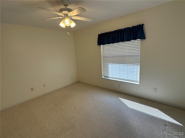 carpeted spare room featuring ceiling fan