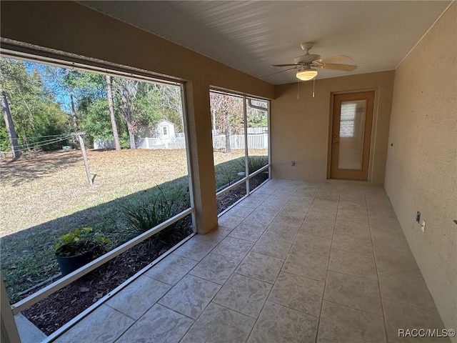 unfurnished sunroom featuring ceiling fan