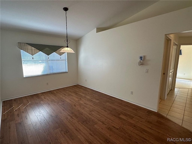 unfurnished dining area with lofted ceiling and hardwood / wood-style floors