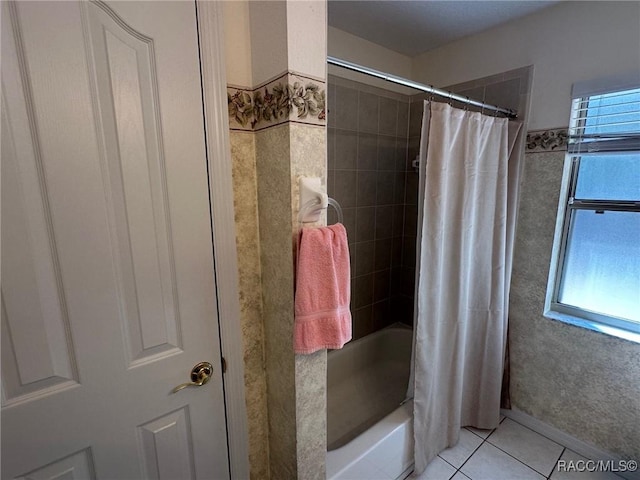 bathroom with tile patterned flooring, a wealth of natural light, and shower / bath combo with shower curtain